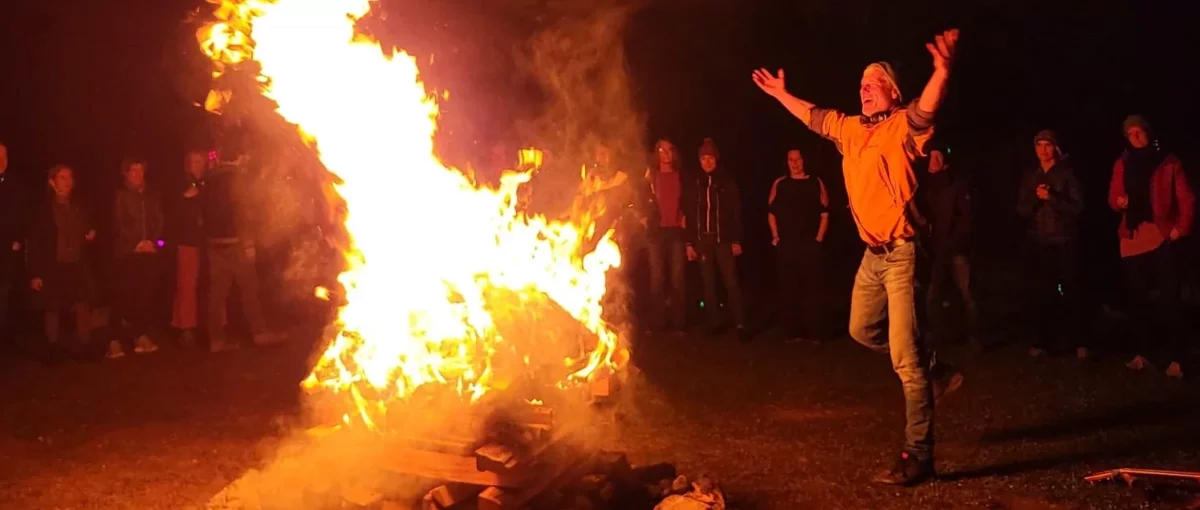 Andreas vor grossem Feuer mit Zuschauenden im Hintergrund